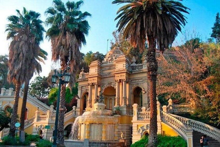 Un edificio histórico con una fuente, palmeras y una escalera. 4