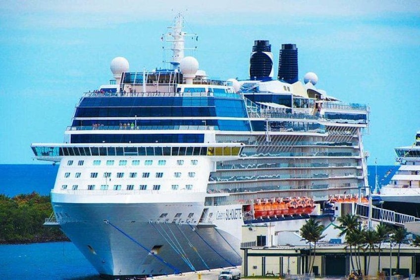 Un grand navire de croisière était amarré dans un port. Il possédait de nombreux ponts et, en arrière-plan, on pouvait admirer un ciel bleu azur. 1