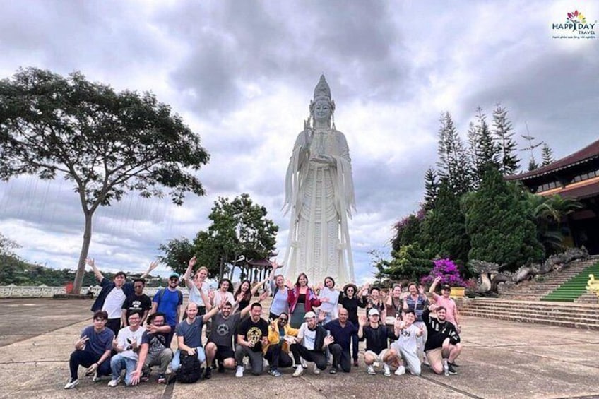 A group of people posing in front of a large white statue. 4