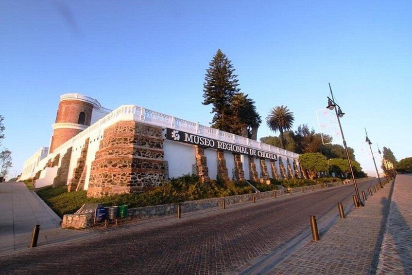 Un museo con fachada de piedra, una torre y un paseo empedrado. 5