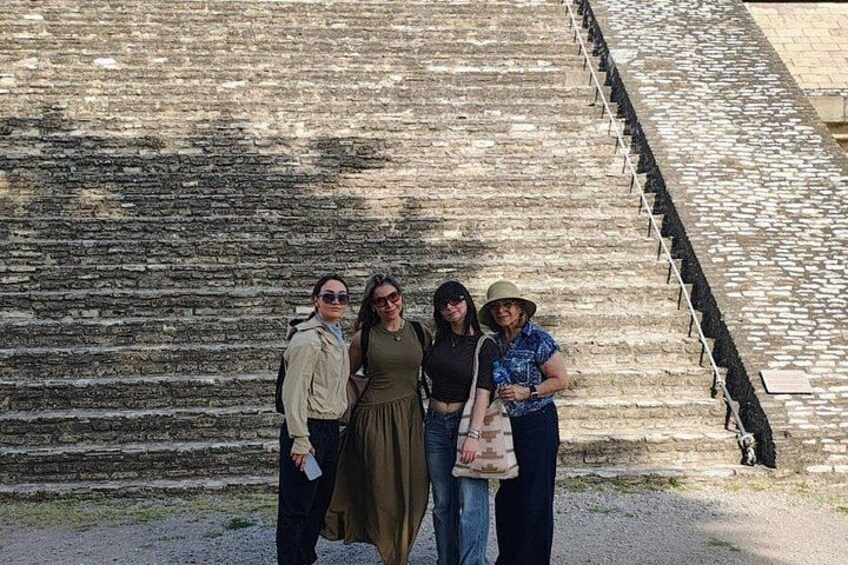Un grupo de personas de pie frente a una escalera de piedra. 2