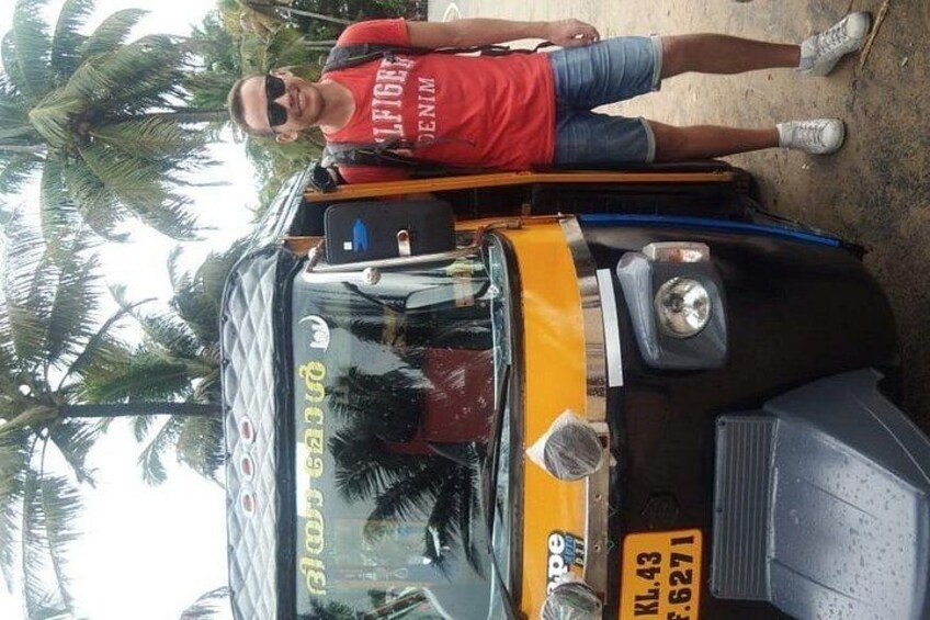 A man standing next to a yellow and black vehicle with a license plate. 4