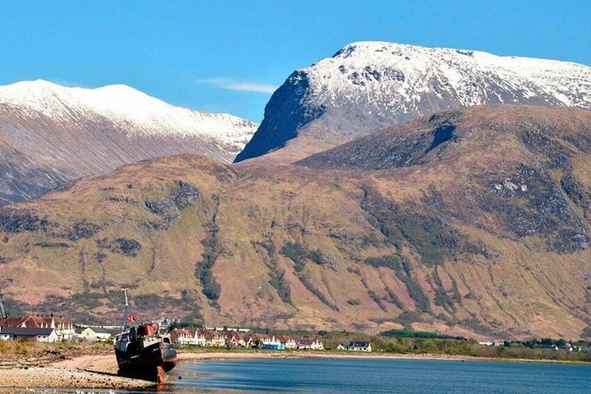 A boat on a lake with mountains in the background. 5