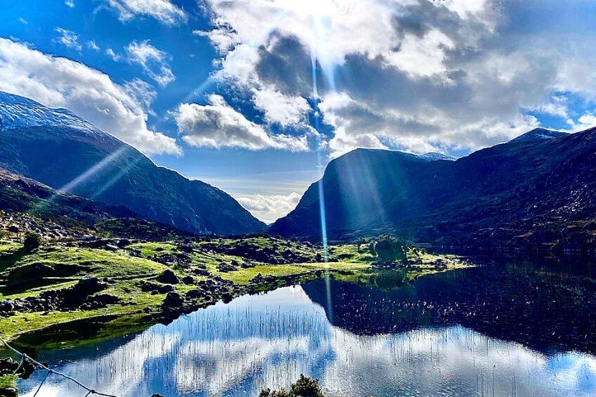 Et bjerglandskab med en sø, der spejler himlen. 3