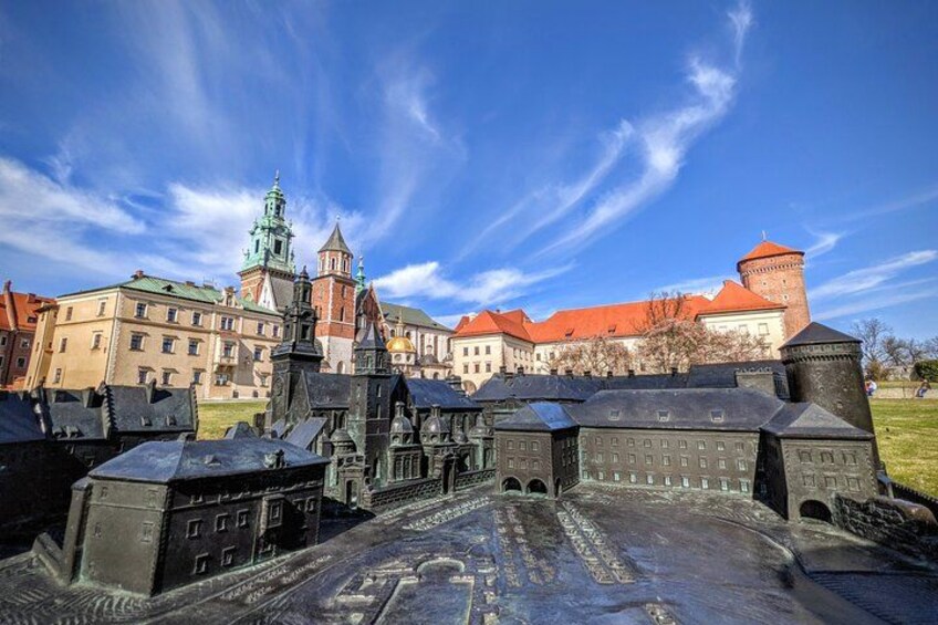 A historic castle complex with multiple buildings, a prominent tower, and a moat. 4
