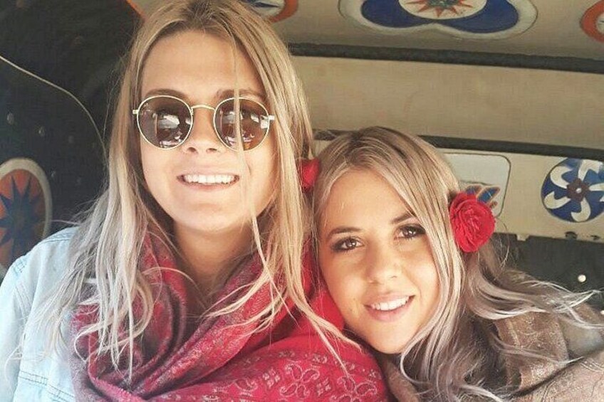 Two people with long hair, one wearing a red scarf and the other with a red flower accessory. 1