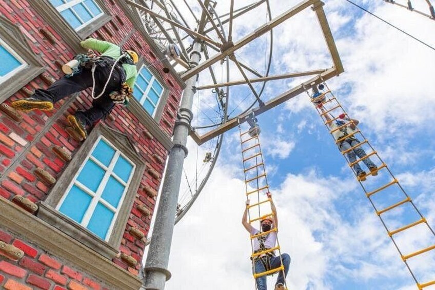 A person rappelling down a metal structure attached to a brick building. 4
