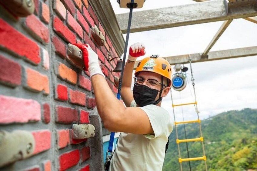 A person wearing a helmet and gloves, working on a brick wall. 5