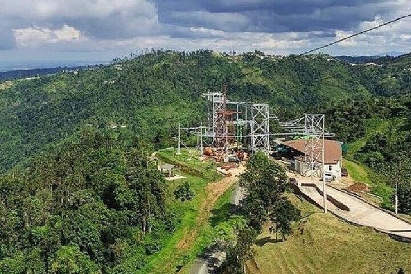 A mountainous landscape with a power transmission tower and a small building. 2