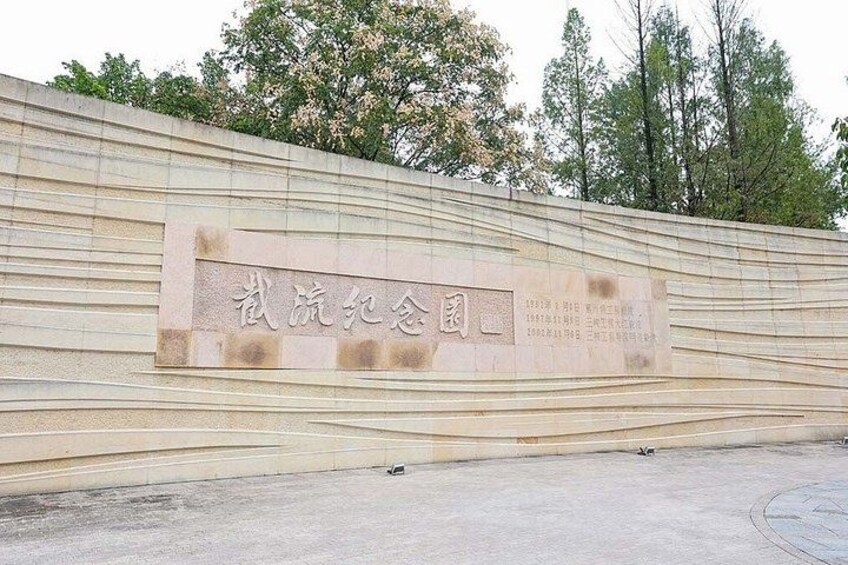 A stone wall with engraved text and a plaque. 5