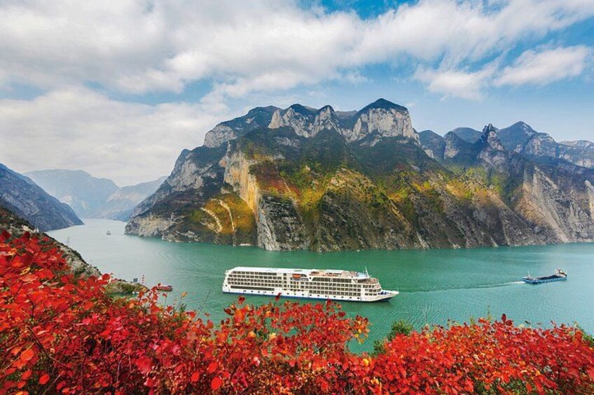 A cruise ship on a calm lake with mountains in the background. 2