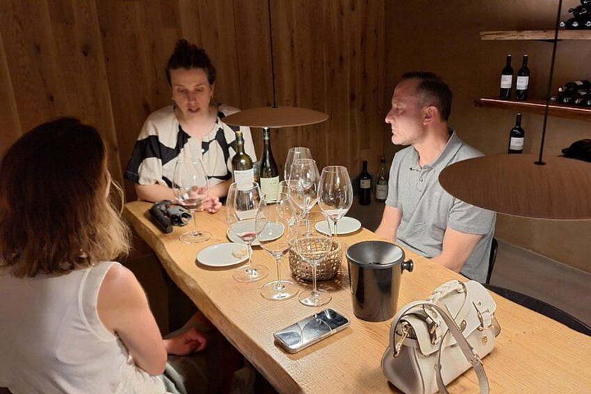 A wooden table with wine bottles, glasses, and a metal bucket. 4