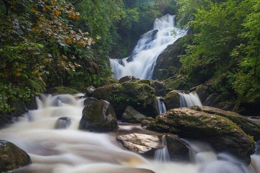 A waterfall surrounded by rocks and greenery. 5
