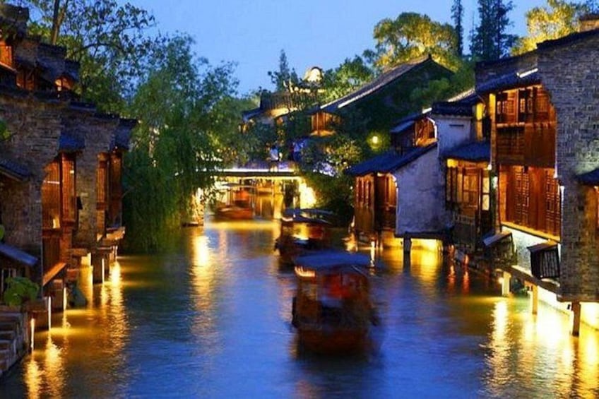 A traditional waterway with buildings on either side, a boat in the water, and a bridge in the background. 2
