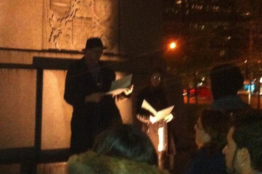 A person standing on a platform, possibly giving a speech or presentation, with a crowd gathered around. 2