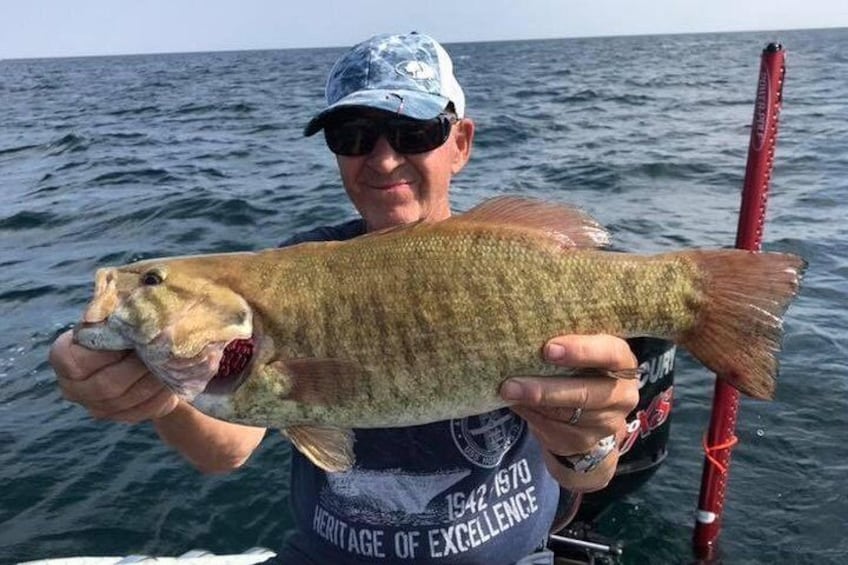A person holding a fish in a body of water. 2