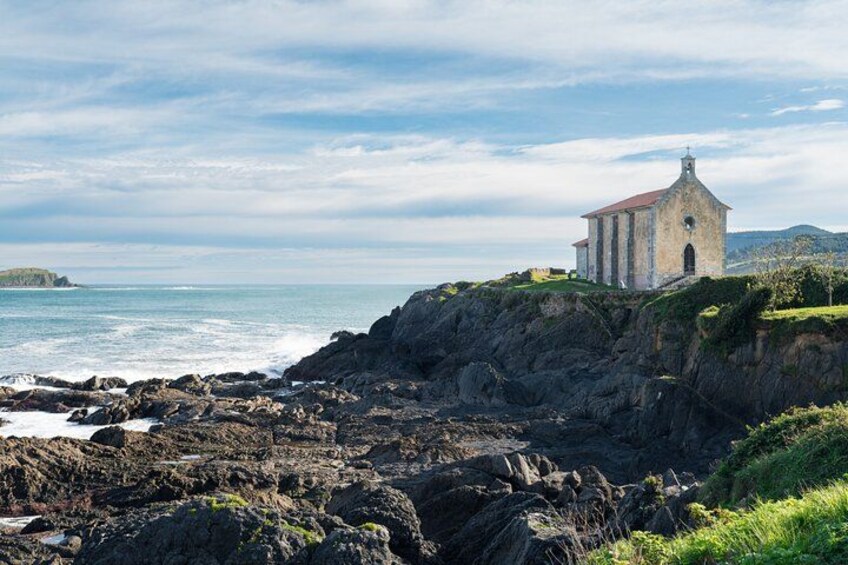 Een kerk aan de kust, op een rotsachtige klif met uitzicht op zee. 4