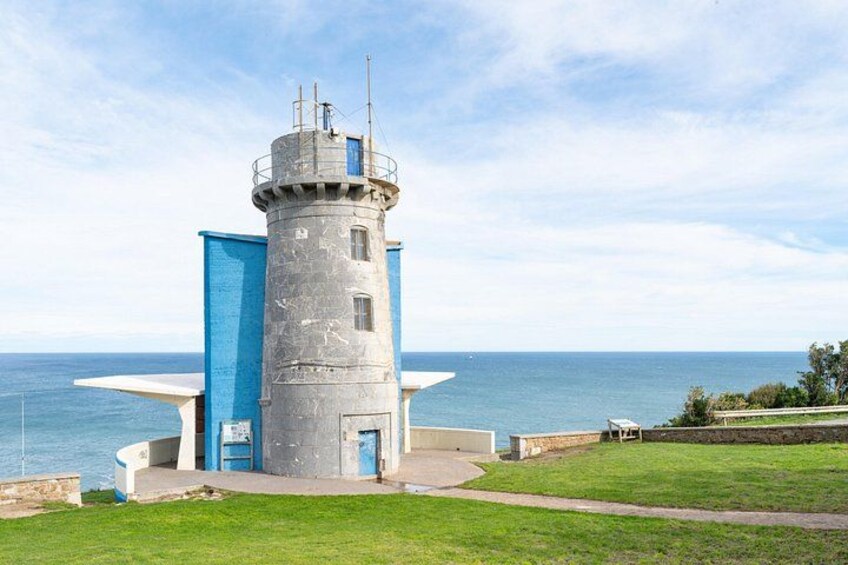 Un faro con una torre cilíndrica y una estructura azul a su lado. 2