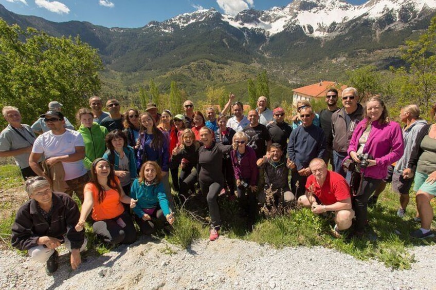 Un gruppo di persone che posano in una zona montana con cime innevate sullo sfondo. 1