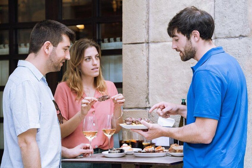 Un groupe de personnes est assis à une table à l’extérieur, où elles prennent un repas et boivent. 3