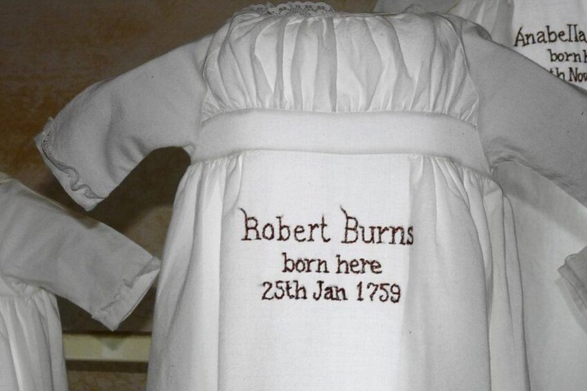 Ett vitt plagg med texten: ”Robert Burns föddes här den 25 januari 1759.” 2