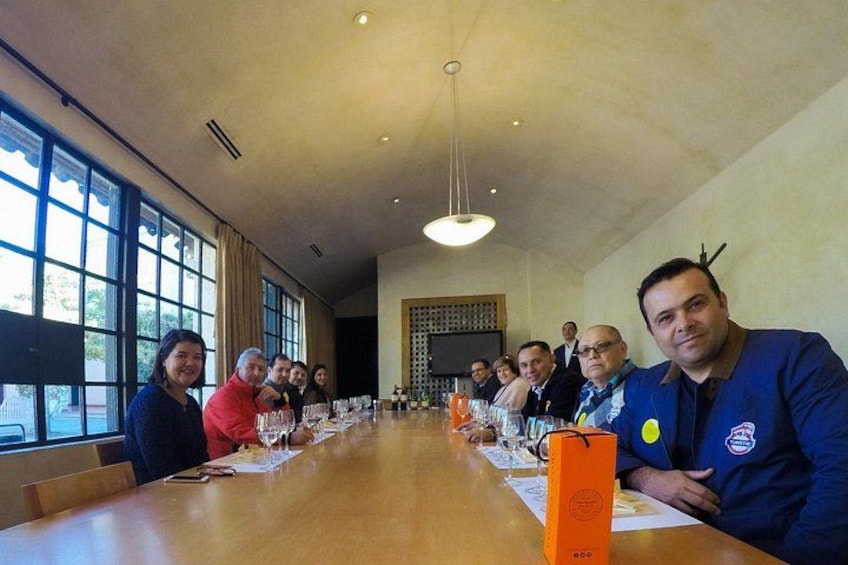 A conference room with a long table, people seated, and a large window. 3