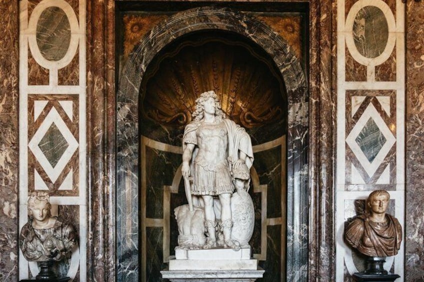 A marble statue in an ornate niche with geometric patterns on the walls. 5