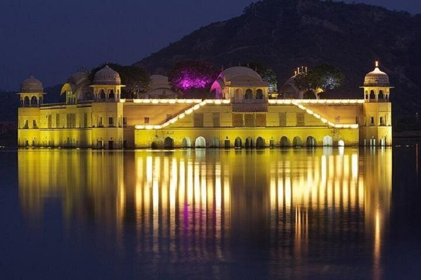 A palace with illuminated arches and domes reflecting on water. 1