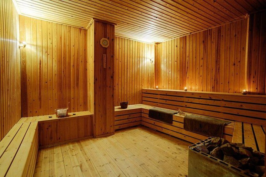 Un sauna en bois avec des bancs et un foyer. 3