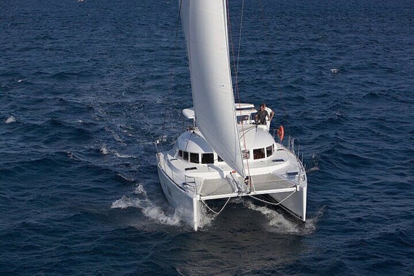 A white sailboat with a large sail on the water. 2