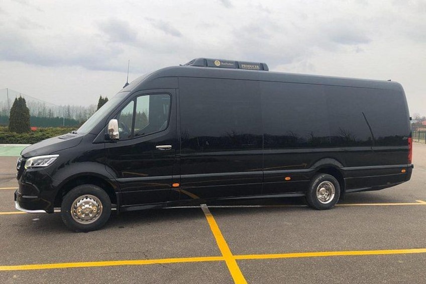 A black van parked in a parking lot with yellow lines. 2