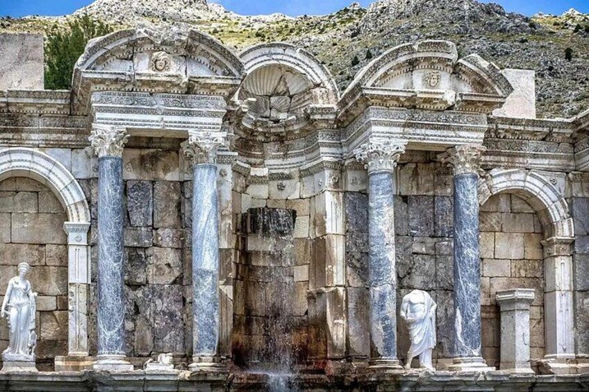 Una estructura de piedra antigua con columnas y estatuas. 1