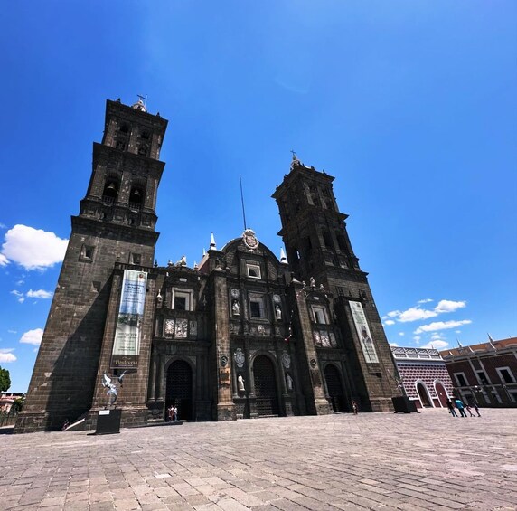 A historic building with two prominent towers and a central dome, featuring intricate architectural details and statues. 5