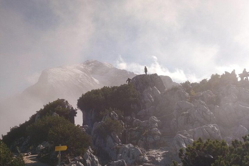 A mountainous landscape with rocky outcrops and a person standing on a peak. 4