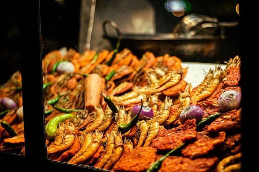 A variety of seafood, including prawns and fish, displayed in a market setting. 5