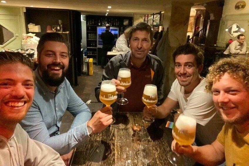 Un grupo de personas sentadas alrededor de una mesa con vasos de cerveza. 2
