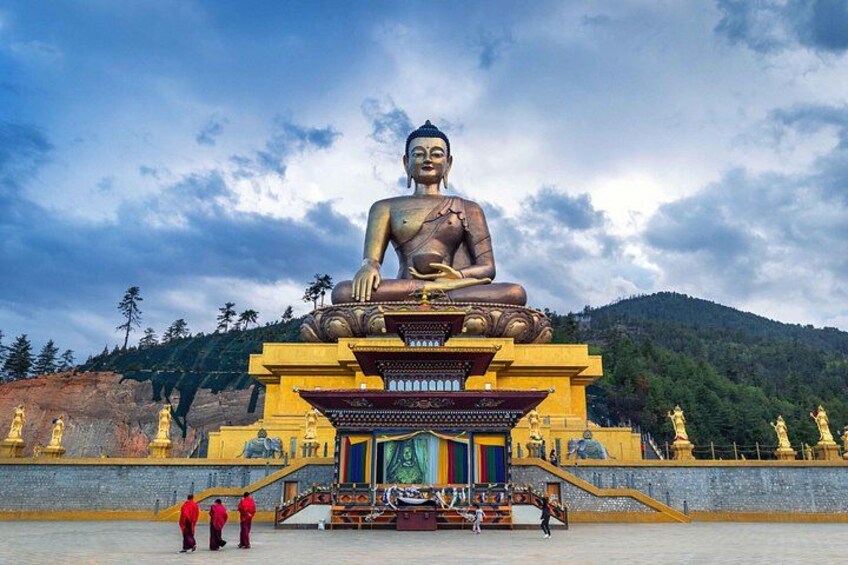 A large seated Buddha statue on a pedestal, surrounded by golden statues and a temple structure. 5