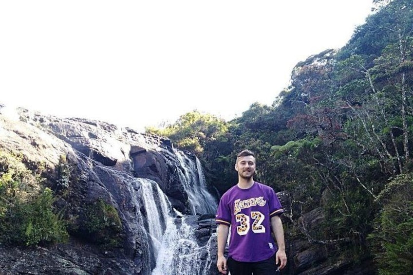 Une cascade, un terrain rocheux et une végétation luxuriante. 2