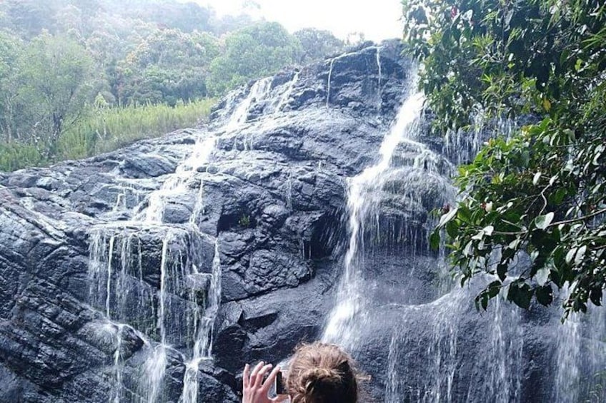 Une cascade se déversant sur une falaise rocheuse, le tout étant entouré de verdure. 3