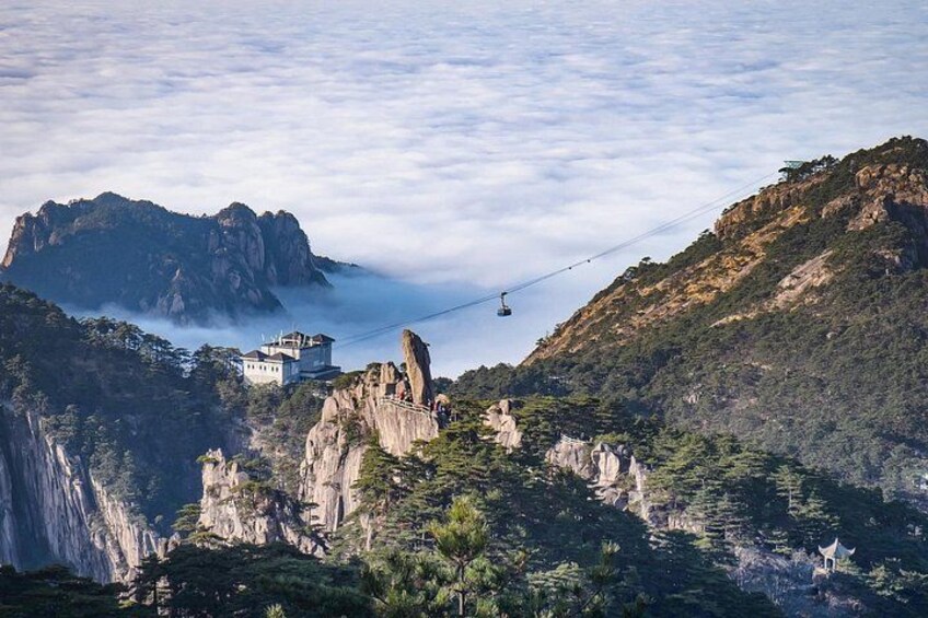 A mountainous landscape with a cable car, a waterfall, and a building on a cliff. 1