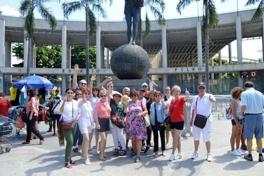 A group of people standing in a public square with a statue in the background. 5