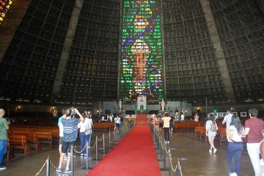 A large indoor space with a red carpet leading to a central area with a colorful illuminated structure. 4