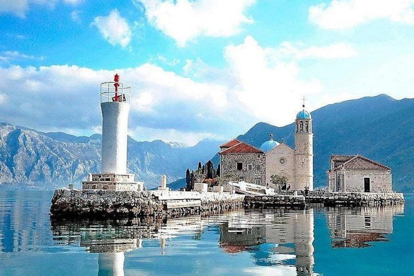 A coastal town with a lighthouse, a church, and a small building. 2