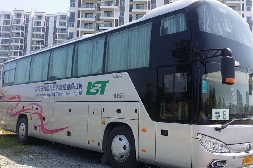 A tour bus with a company logo and a passenger capacity sign. 2