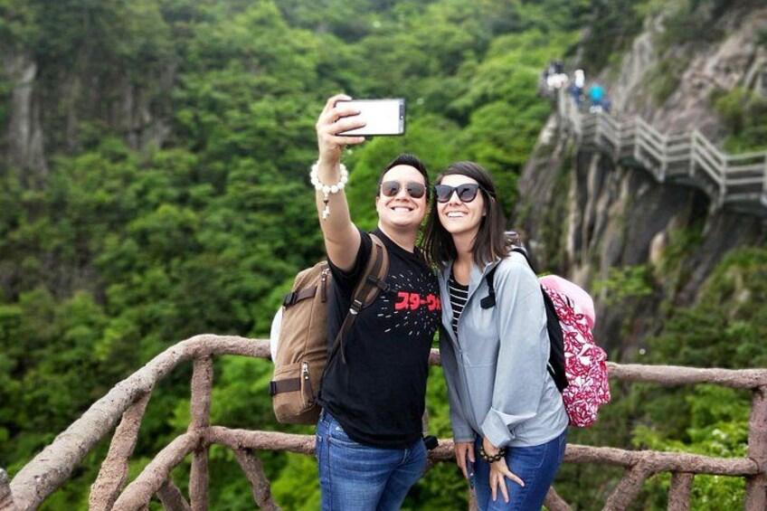 Two people taking a selfie with a scenic mountainous background. 3
