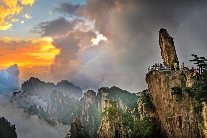 A mountainous landscape with a prominent rock formation and a viewing platform. 4
