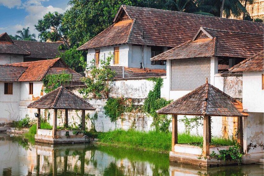 Traditional houses with tiled roofs, a calm water body, and lush greenery. 2