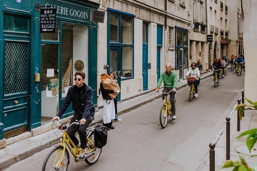 A street with cyclists, a building with a sign reading 'ERIE GOGOS,' and a person carrying a bag. 5