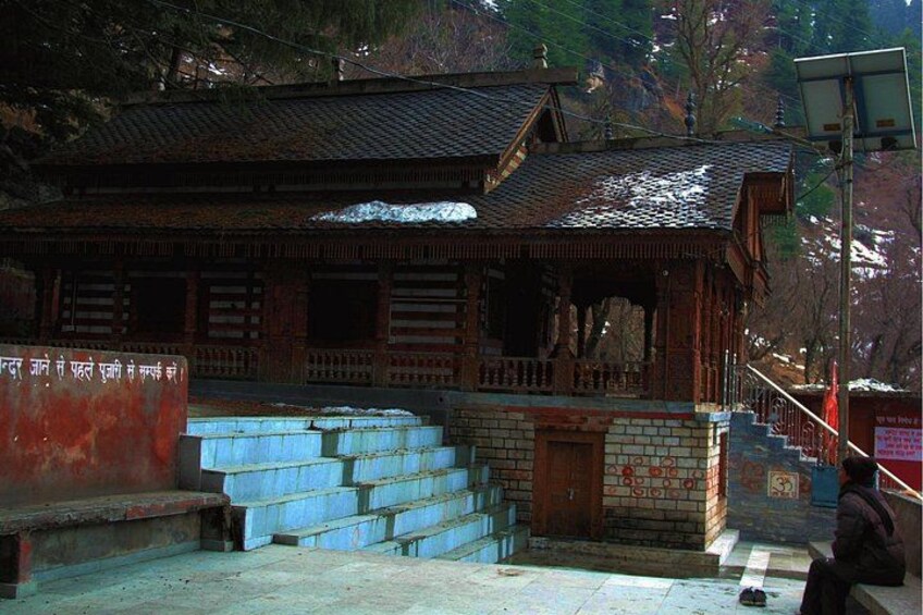 A traditional wooden building with a tiled roof and a staircase leading up to it. 4