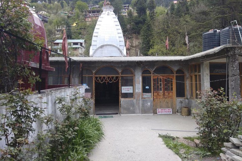 A temple with a white dome and a wooden entrance. 3
